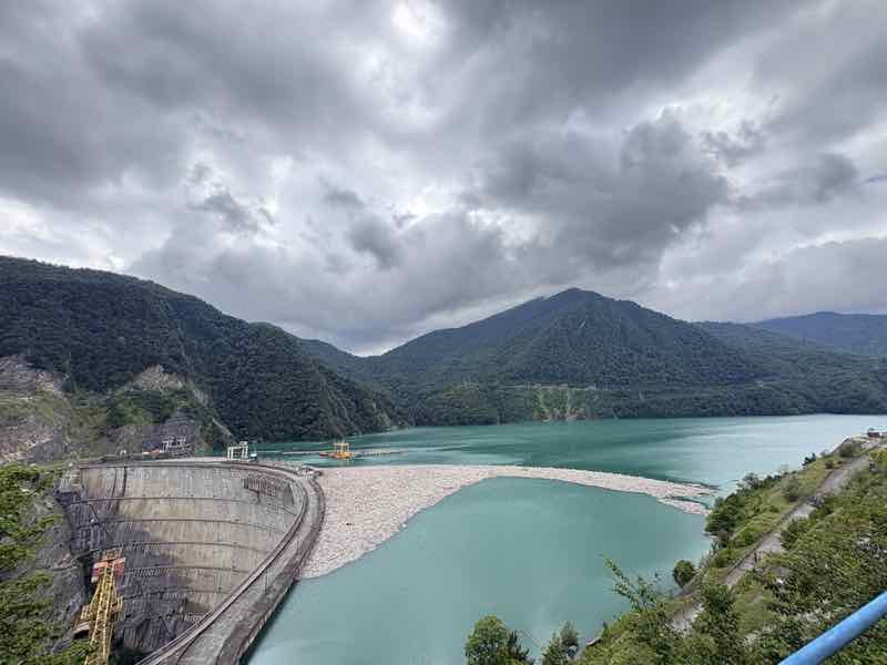 Türkiser Stausee umgeben von Bergen