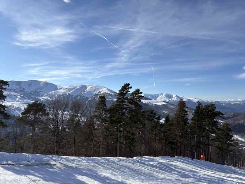 Skipiste mit Blick auf verschneite Berge